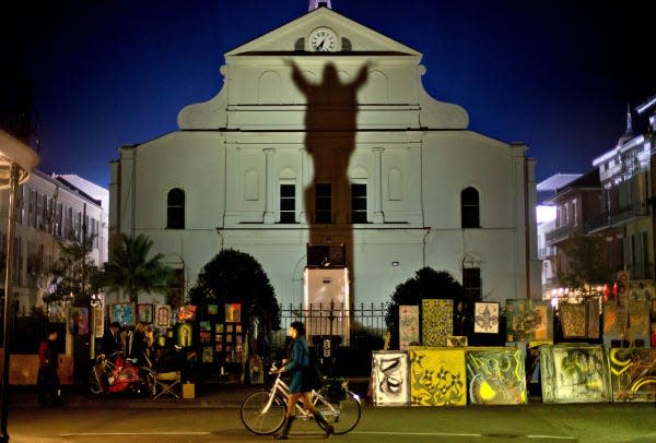 The image of Jesus is projected in shadow on the Cathedral-Basilica of Saint Louis King of France in New Orleans.