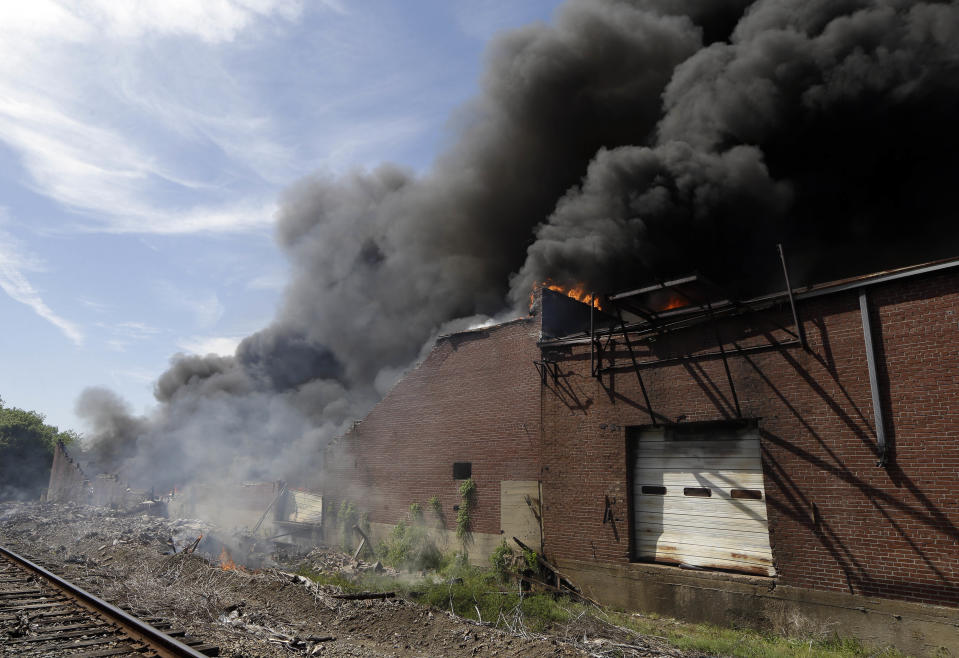 A commercial building burns near downtown Memphis, Tenn., on Saturday, April 26, 2014. Officials say four Memphis firefighters were rescued from the burning building after a wall collapsed on them. (AP Photo/Mark Humphrey)