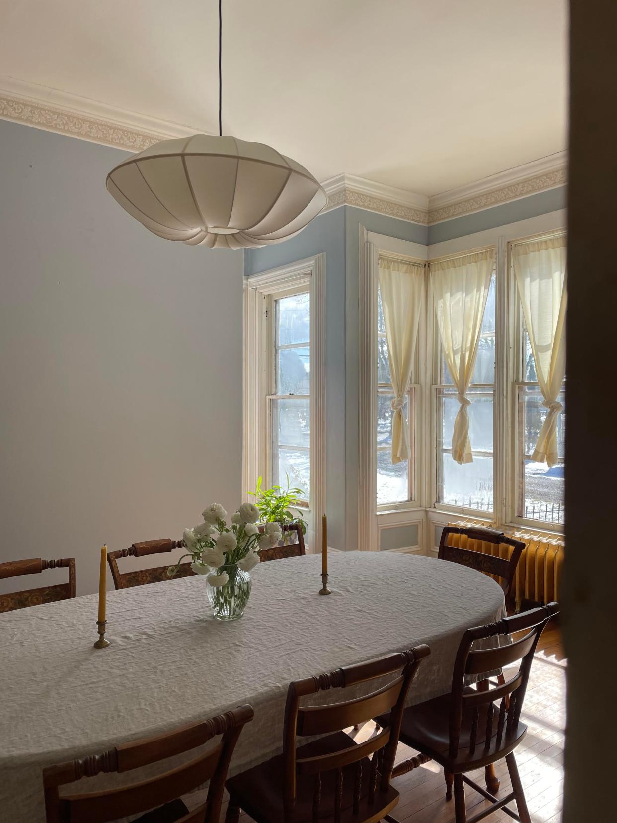 A dining room with large windows and blue walls.