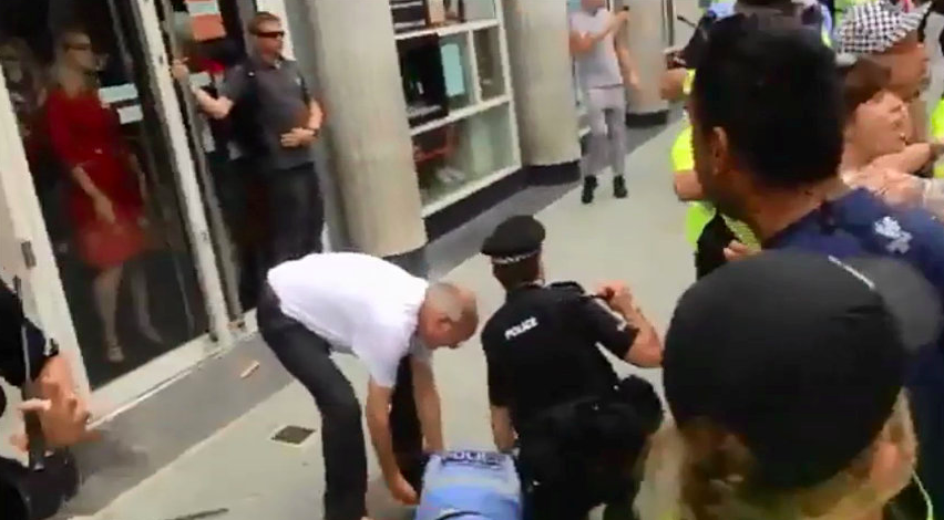 <em>The officer was sent sprawling onto the pavement while officers struggled to keep members of the far right group away from rival protesters (SWNS)</em>