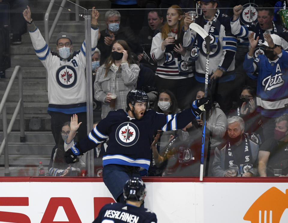 Winnipeg Jets' Adam Lowry (17) celebrates his goal against the Nashville Predators during the first period of NHL hockey game action in Winnipeg, Manitoba, Saturday, Oct. 23, 2021. (Fred Greenslade/The Canadian Press via AP)