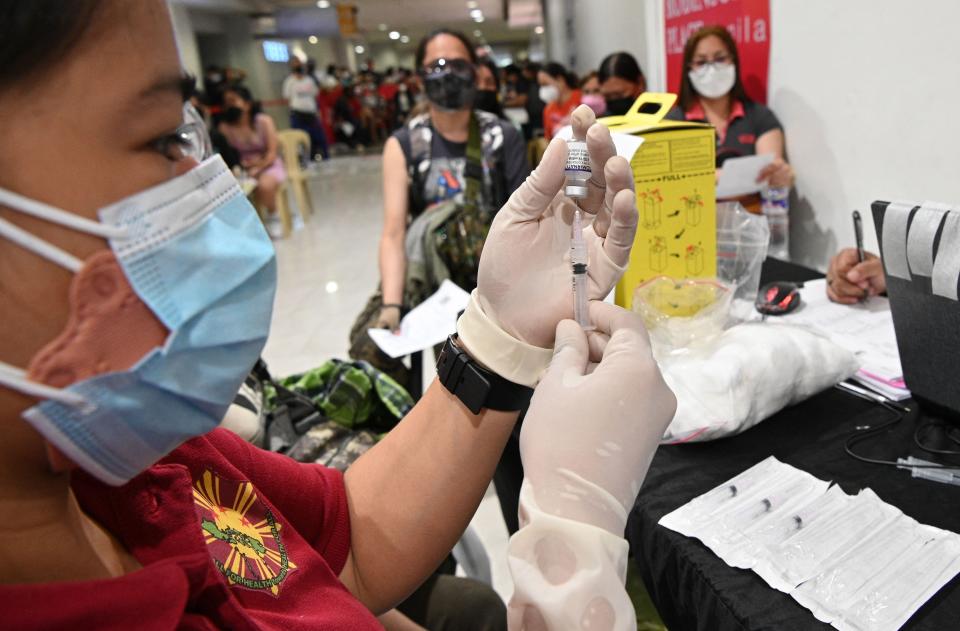 A medical worker prepares a BioNtech-Pfizer Covid-19 coronavirus vaccine inside a mall in Manila City, on 29 November 2021 (AFP via Getty Images)