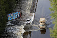 Esta fotografía del lunes 17 de septiembre de 2018 muestra un vehículo de la Guardia Costera que pasa entre las aguas de las inundaciones provocadas por el huracán Florence en Dillon, Carolina del Sur. (AP Foto/Gerald Herbert)