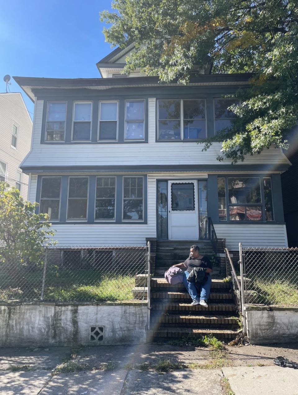 Latasha Tatum sits on the steps of her family home the week she must vacate. She plans to put all her family’s belongings in storage. (Photo by Natasha S. Alford/theGrio)