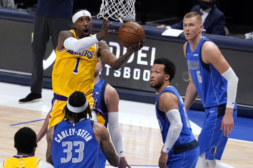 Los Angeles Lakers guard Kentavious Caldwell-Pope (1) shoots as Dallas Mavericks' Willie Cauley-Stein (33), Jalen Brunson and Kristaps Porzingis (6) defend during the second half of an NBA basketball game in Dallas, Thursday, April 22, 2021. (AP Photo/Tony Gutierrez)