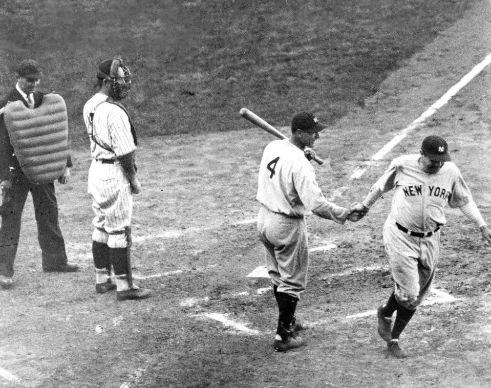 Babe Ruth is greeted at home plate by Lou Gehrig after hitting his famous 