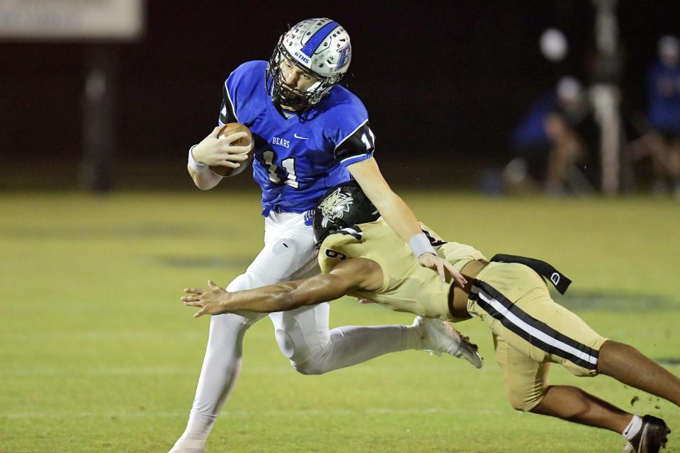 Bartram Trail's Riley Trujillo (11) tries to avoid the tackle from Buchholz's Jacarree Kelly (9) during first quarter action. The Bartram Trail Bears football team hosted Gainesville's Buchholz Bobcats at the Bears Saint Johns stadium Friday, November 25, 2022. With the Buchholz's Friday night 21 to 20 win in the FHSAA Region 1-4S high school football final, the Bobcats's advance to the final four.