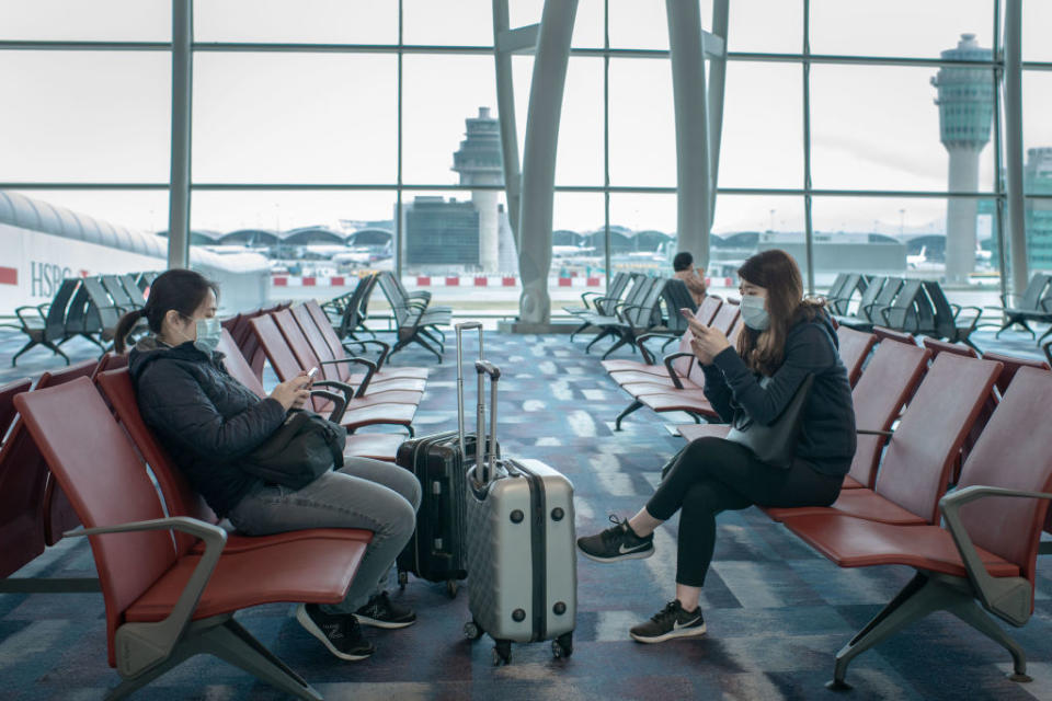 Travellers wear masks at an airport in Hong Kong (Getty)