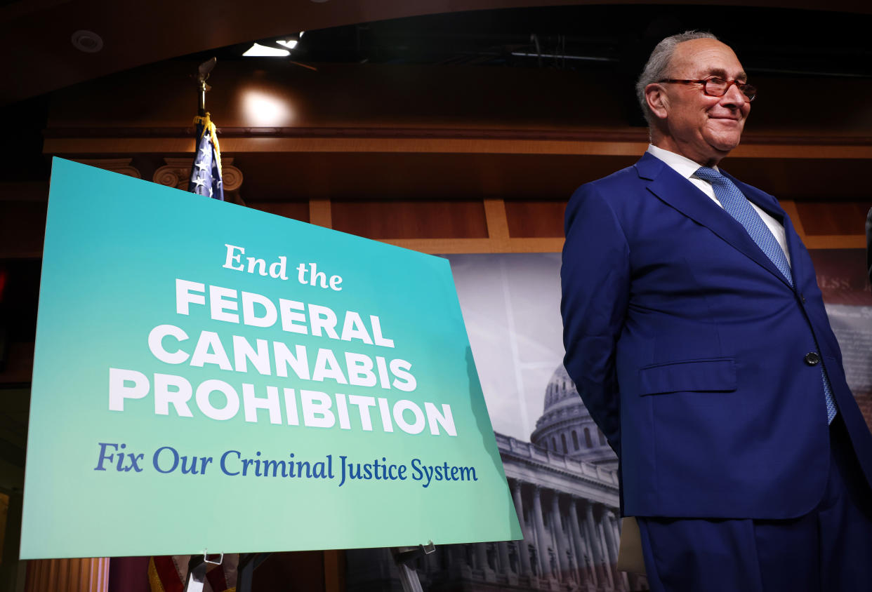 Chick Schumer stands next to a sign that reads End the Federal Cannabis Prohibition.