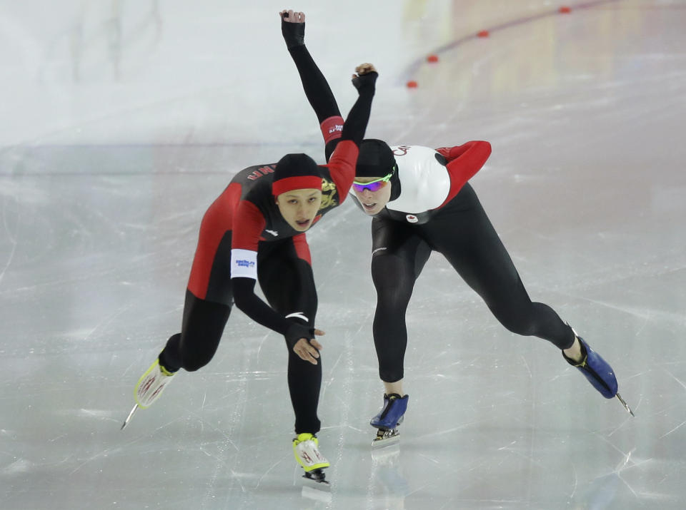 China's Zang Hong, left, and Canada's Christine Nesbitt compete in the women's 1,000-meter speedskating race at the Adler Arena Skating Center during the 2014 Winter Olympics in Sochi, Russia, Thursday, Feb. 13, 2014. (AP Photo/David J. Phillip )