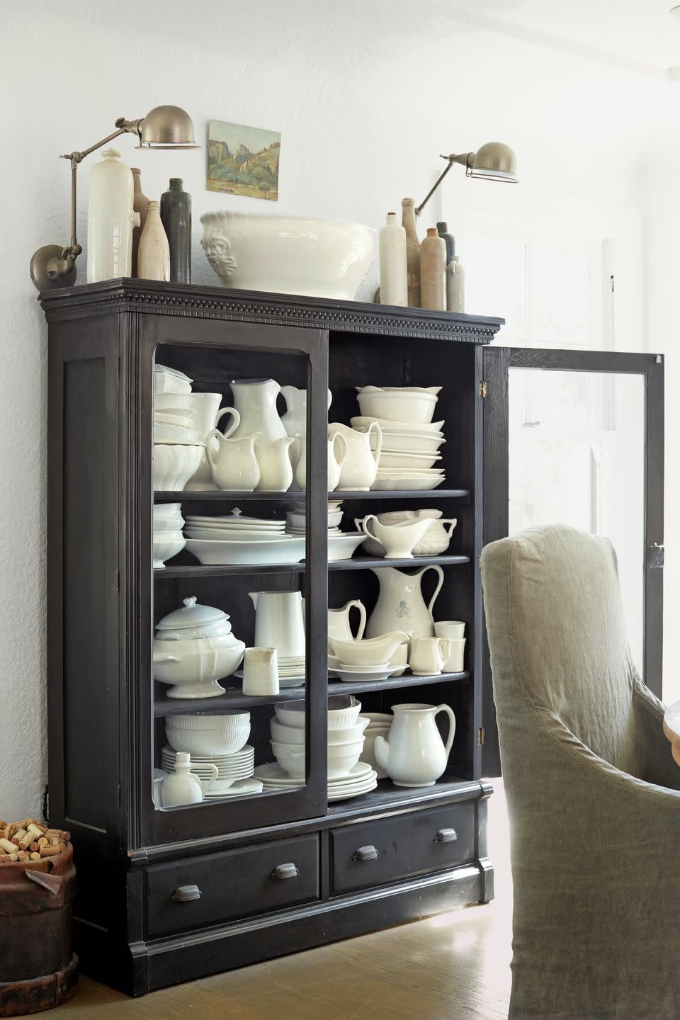 a black cabinet with white ironstone dishes