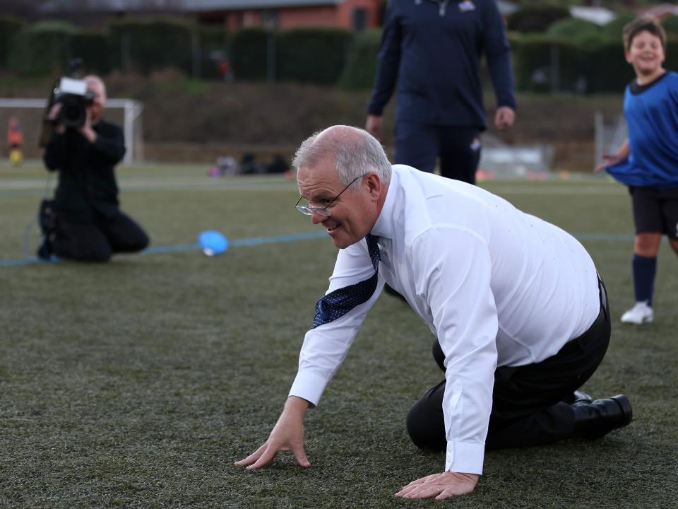 Prime Minister Scott Morrison falls over after accidentally knocking over a child during a visit to the Devonport Strikers Soccer Club, which is in the electorate of Braddon, on May 18, 2022 in Devonport, Australia.