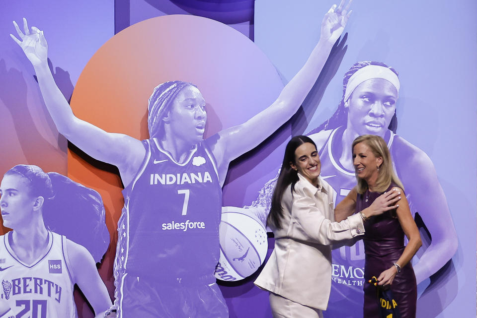 CORRECTS TO CAITLIN CLARK NOT CAITLYN CLARK - Iowa's Caitlin Clark, left, greets WNBA commissioner Cathy Engelbert, right, after being selected first overall by the Indiana Fever during the first round of the WNBA basketball draft, Monday, April 15, 2024, in New York. (AP Photo/Adam Hunger)