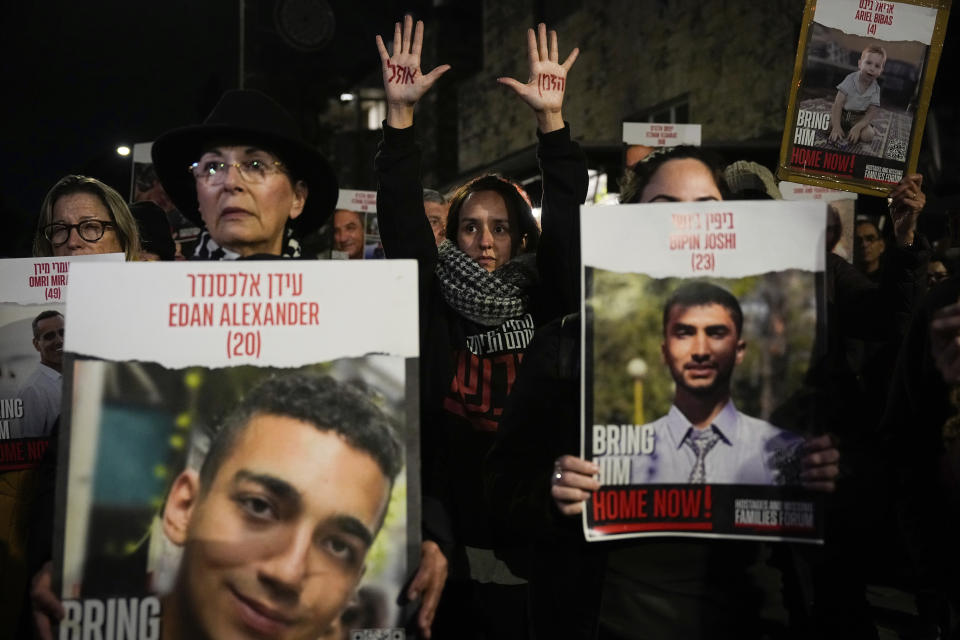 Relatives and supporters of the Israeli hostages held in the Gaza Strip by the Hamas militant group attend a protest calling for their release outside the Knesset, Israel's parliament, in Jerusalem, Monday, Jan. 22, 2024. Hebrew on the hands reads, "Time is running out". (AP Photo/Ohad Zwigenberg)