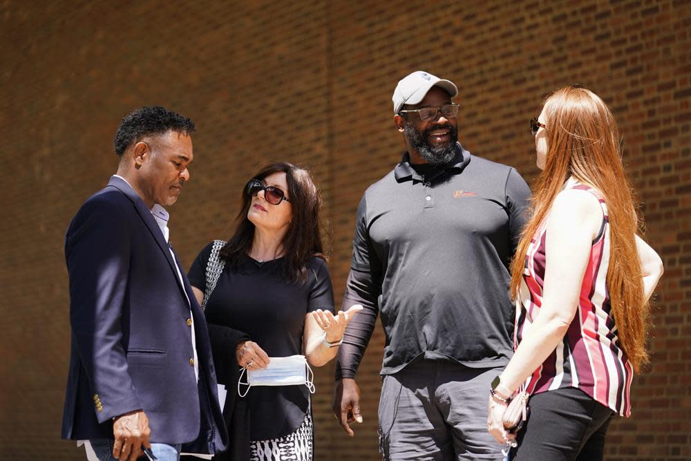 From left, former NFL player Ken Jenkins and his wife Amy Lewis, along with former NFL player Clarence Vaughn III and his wife Brooke Vaughn, meet before delivering tens of thousands of petitions demanding equal treatment for everyone involved in the settlement of concussion claims against the NFL, to the federal courthouse in Philadelphia, Friday, May 14, 2021. (AP Photo/Matt Rourke)