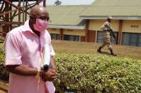 Paul Rusesabagina, portrayed as a hero in a Hollywood movie about Rwanda's 1994 genocide, is escorted in handcuffs from the courtroom in Kigali