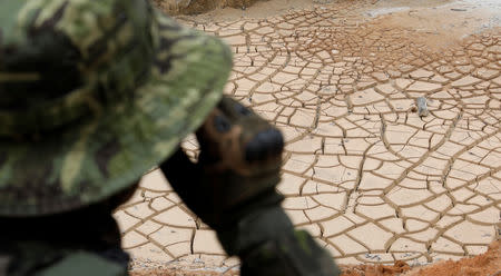 A specialised agent patrols an illegal cassiterite mine during an operation conducted by agents of the Brazilian Institute for the Environment and Renewable Natural Resources, or Ibama, in national parks near Novo Progresso, southeast of Para state, Brazil, November 4, 2018. REUTERS/Ricardo Moraes