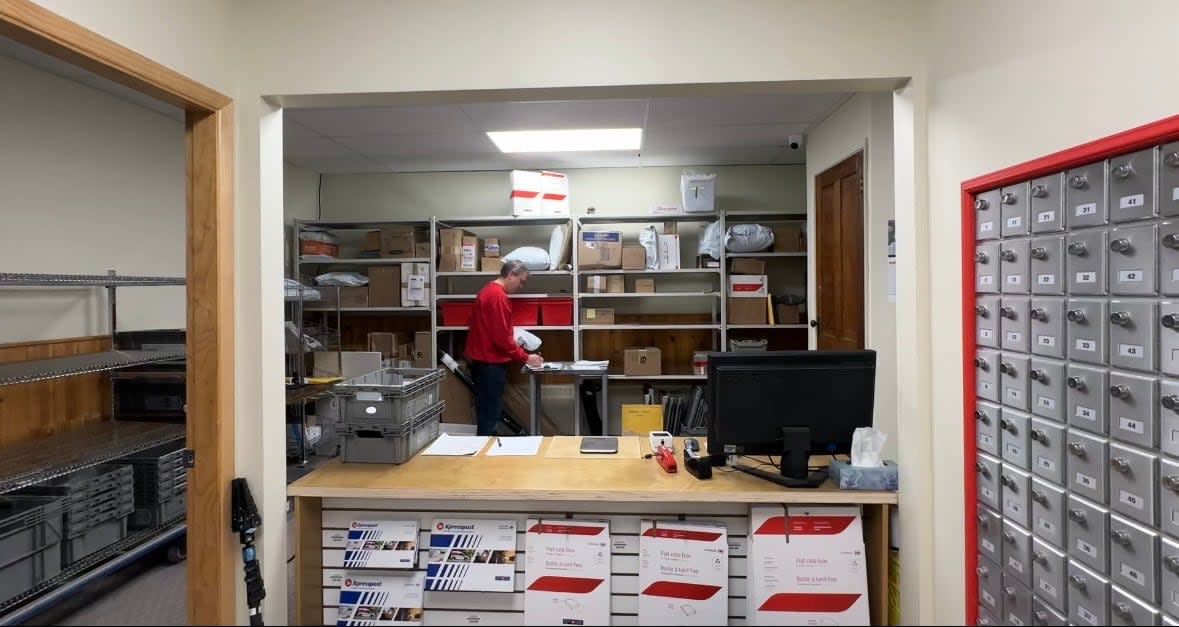 Stephen Lancaster, manager of the Atlin, B.C., post office, at its new location in the Atlin Mountain Inn. The community's last permanent post office burned down more than a year ago. (Virginie Ann/CBC - image credit)