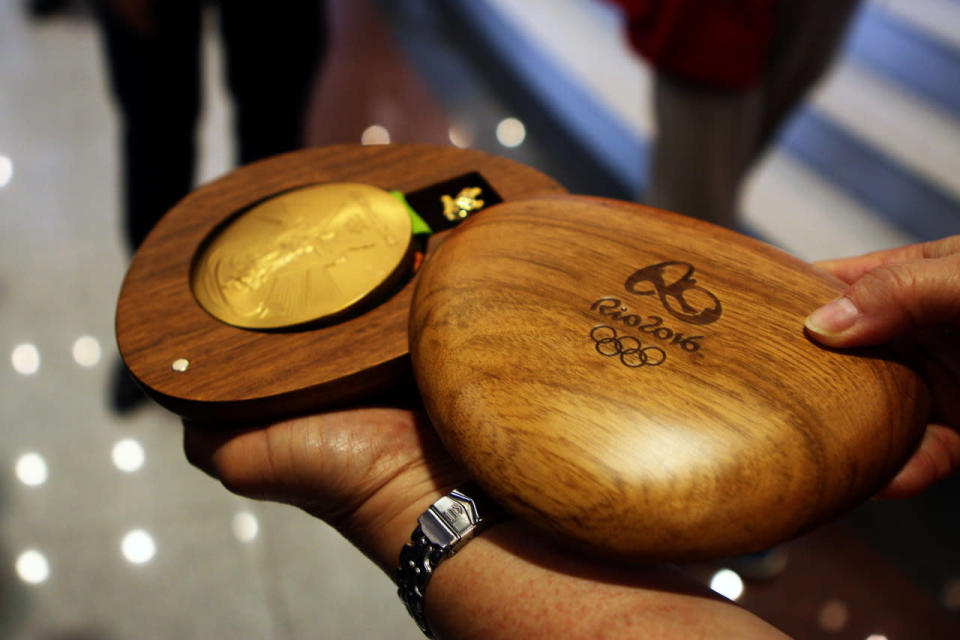 May Schooling holding Joseph’s Rio Olympics gold medal. (Yahoo Newsroom)