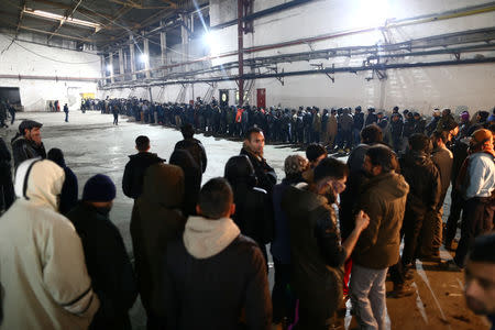 Migrants wait for food in a migrant camp in Bihac, Bosnia and Herzegovina, December 14, 2018. REUTERS/Antonio Bronic