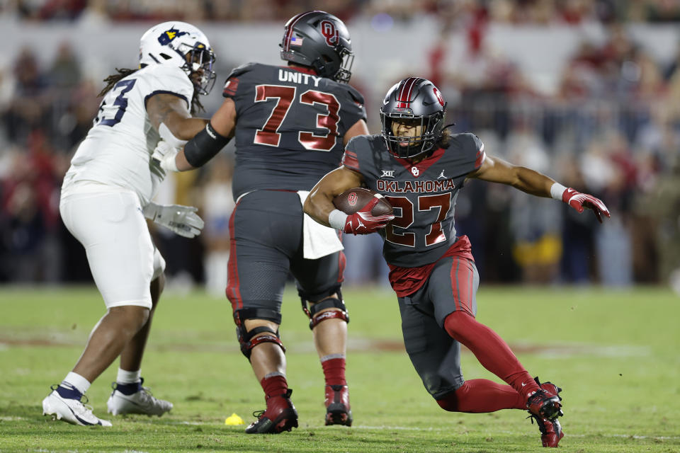 Oklahoma running back Gavin Sawchuk (27) runs for a first down against West Virginia during the first half of an NCAA college football game Saturday, Nov. 11, 2023, in Norman, Okla. (AP Photo/Alonzo Adams)