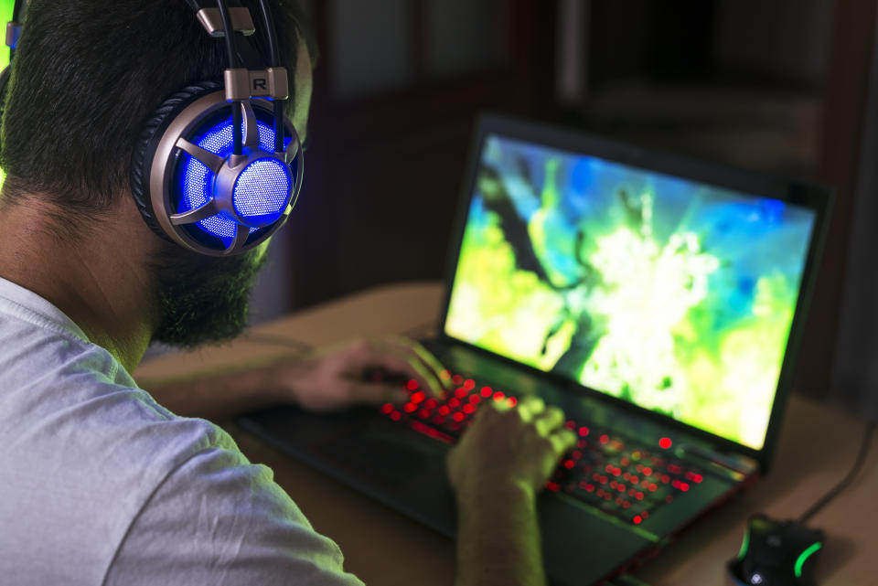 a person on a gaming laptop and headphones on