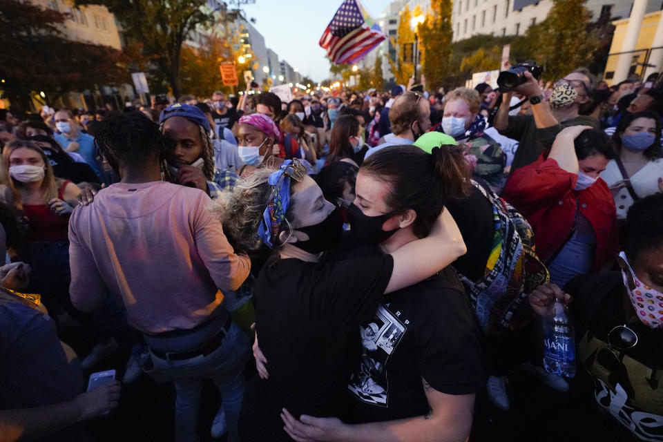 People gather in Black Lives Matter Plaza to celebrate president-elect Joe Biden's win over Pres. Donald Trump to become the 46th president of the United States, Saturday, Nov. 7, 2020, in Washington. His victory came after more than three days of uncertainty as election officials sorted through a surge of mail-in votes that delayed the processing of some ballots. (AP Photo/Alex Brandon)