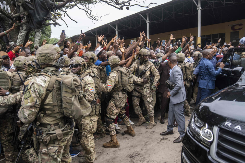 Security forces try to control crowds of supporters of President Felix Tshisekedi, after he cast his ballot inside a polling station during the presidential elections in Kinshasa, Democratic Republic of Congo, Wednesday, Dec. 20, 2023. Congo saw opening delays of up to seven hours in a presidential election Wednesday facing steep logistical and security challenges that raised questions about the credibility of the vote. (AP Photo/Mosa'ab Elshamy)