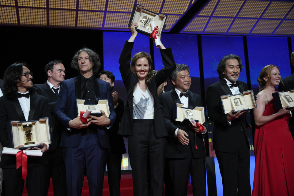 Pham Thien An winner of the Camera d'or award for 'Inside The Yellow Cocoon Shell,' from left, Quentin Tarantino, Jonathan Glazer winner of the jury prize award for 'The Zone of Interest', Justine Triet winner of the Palme d'Or for 'Anatomy of a Fall,' Hirokazu Koreeda holding the award for best screenplay for 'Monster' on behalf of Yuji Sakamoto, Koji Yakusho winner of the award for best actor for 'Perfect Days,' and Alma Poysti winner of the jury prize award for 'Dead Leaves,' appear during the awards ceremony of the 76th international film festival, Cannes, southern France, Saturday, May 27, 2023 (AP Photo/Daniel Cole)