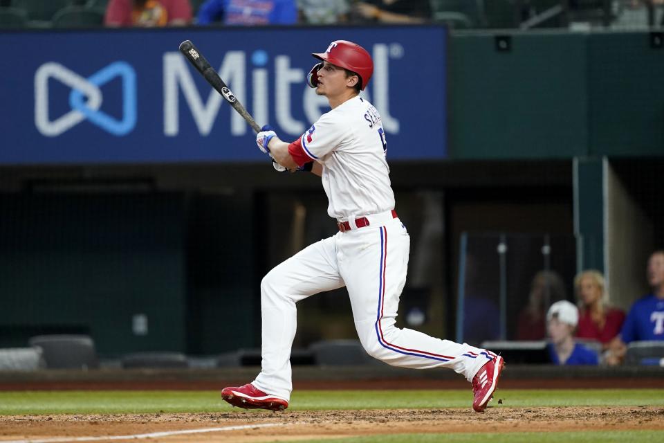 Texas Rangers' Corey Seager follows through on a two-run home run swing in the eighth inning of a baseball game against the Los Angeles Angels in Arlington, Texas, Thursday, Sept. 22, 2022. The shot also scored Marcus Semien. (AP Photo/Tony Gutierrez)