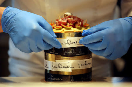 Staff member puts a ribbon on a snack cake at Iginio Massari's new patisserie during the inauguration in downtown Milan, Italy, March 12, 2018. REUTERS/Stefano Rellandini