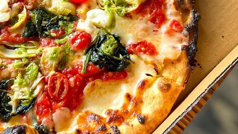 Pizza with pesto, spinach, tomato
