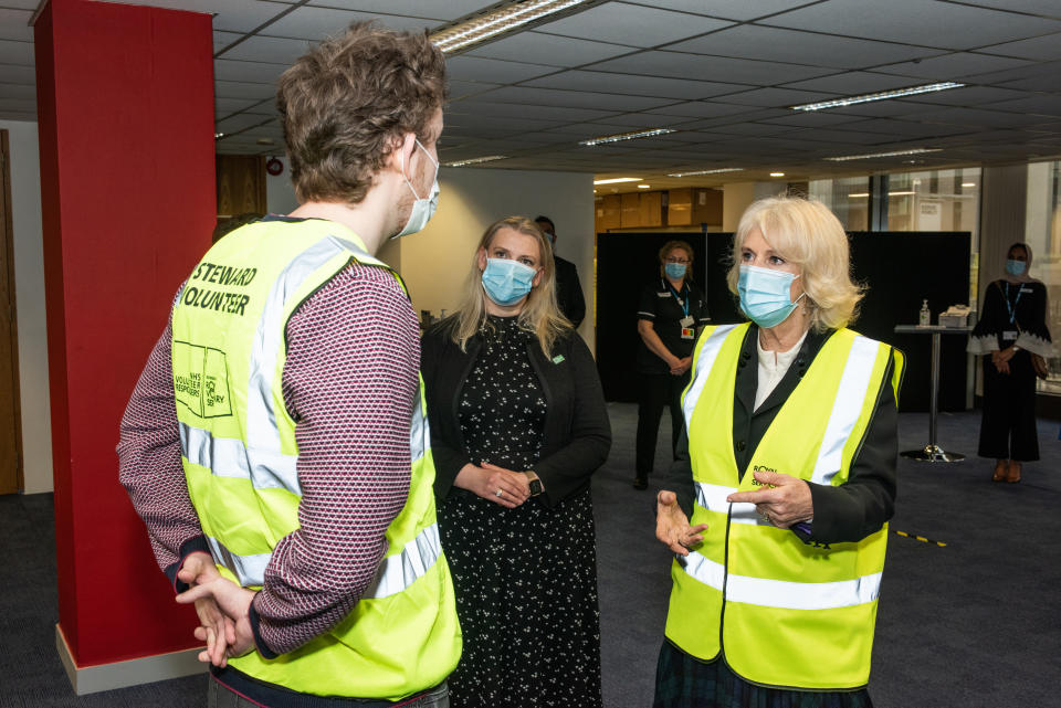 LONDON, ENGLAND - FEBRUARY 23:  Camilla, Duchess of Cornwall, Royal Voluntary Service President, speaks to James Leggett, a NHS Volunteer Responder Steward at Wembley Vaccination Centre on February 23, 2021 in London, England. (Photo by Philip Hartley-WPA Pool/Getty Images)