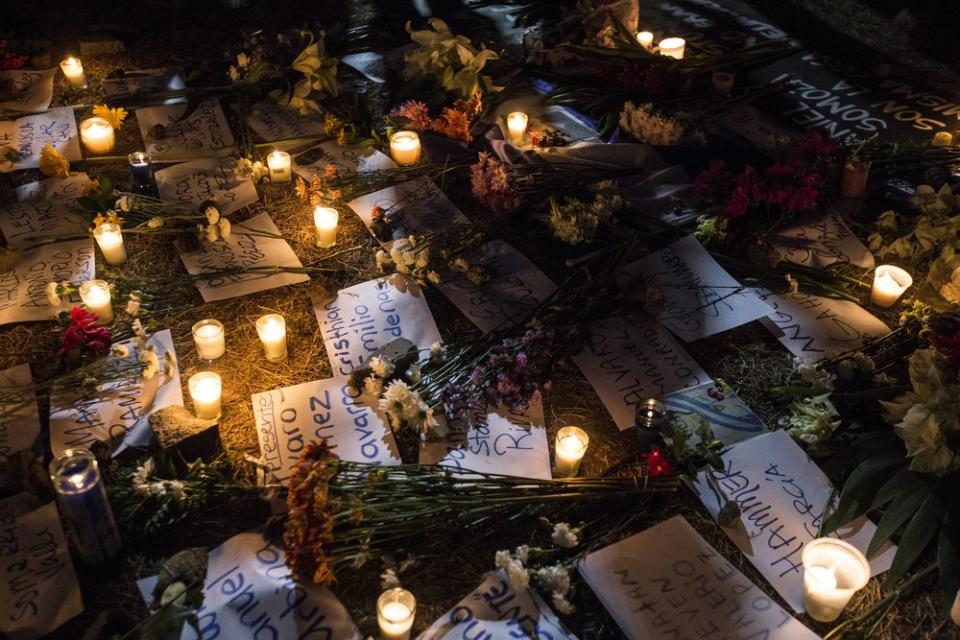 Flowers and candles surround papers written with the names of victims, who were killed during the protests, on April 25.