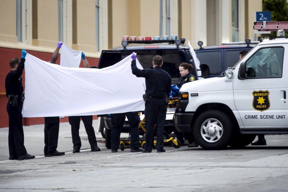 Berkeley Police move a body at the scene of a 4th-story apartment building balcony collapse in Berkeley, California