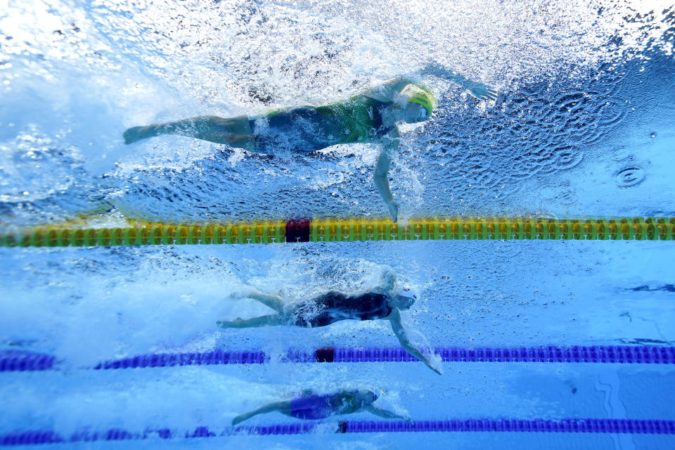 Emma Mckeon, top, of Australia, swims to set an olympic record in a women's 50-meter freestyle semifinal followed by Katarzyna Wasick, center, of Poland, and Arina Surkova, bottom, of the Russian Olympic Committee, at the 2020 Summer Olympics, Saturday, July 31, 2021, in Tokyo, Japan. (AP Photo/Jeff Roberson)