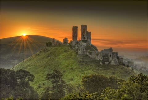 Corfe Castle at dawn - Credit: Getty