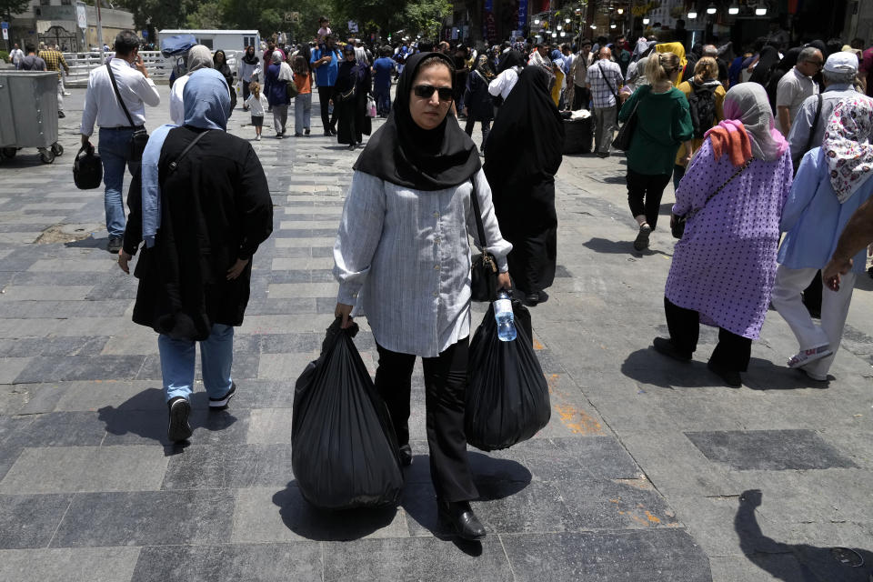 A woman carries her shopping in the old main bazaar of Tehran, Iran, Thursday, June 13, 2024. The rise of the “Hamster Kombat” app in Iran highlights a harsher truth facing the Islamic Republic's economy ahead of its presidential election this week to replace the late President Ebrahim Raisi, who died in a helicopter crash in May. (AP Photo/Vahid Salemi)