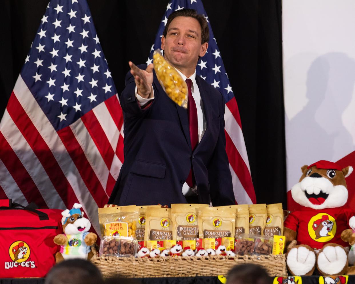 Florida Gov. Ron DeSantis throws bags of Buc-ee's to people attending his press conference in Ocala on April 7. He visited Marion County to reveal that $4 million will be allocated by the state to build an Interstate 75 exchange. A Buc-ee's convenience store will be built nearby.
