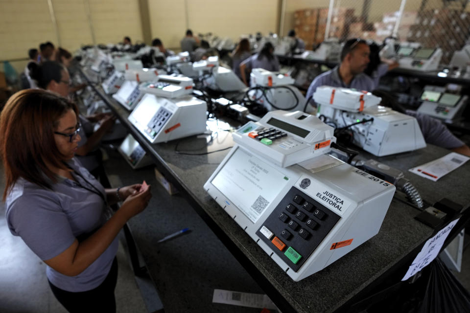Electoral Court employees work on the final stage of sealing electronic voting machines in preparation for the general election run-off in Brasilia, Brazil, Wednesday, Oct. 19, 2022. The second round is set for Oct. 30. (AP Photo/Eraldo Peres)