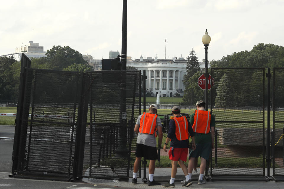 FILE - In this June 10, 2020, file photo workers remove a security fence near the White House in Washington. The fence was erected as protests over the death of George Floyd, a black man who was in police custody in Minneapolis, moved to Washington. Americans are deeply unhappy about the state of their country, and a majority think President Donald Trump is doing more to divide the nation than unite it, according to a new poll from The Associated Press-NORC Center for Public Affairs Research. (AP Photo/Maya Alleruzzo, File)