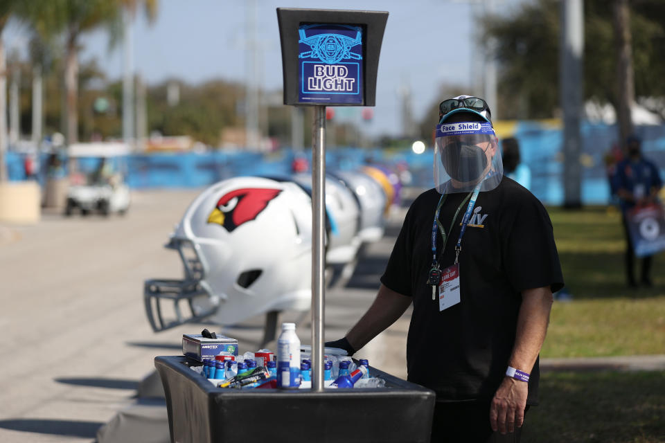 A vendor wears a mask while selling merchandise ahead of Super Bowl LV between the Tampa Bay Buccaneers and the Kansas City Chiefs at Raymond James Stadium on February 07, 2021 in Tampa, Florida. (Photo by Patrick Smith/Getty Images)