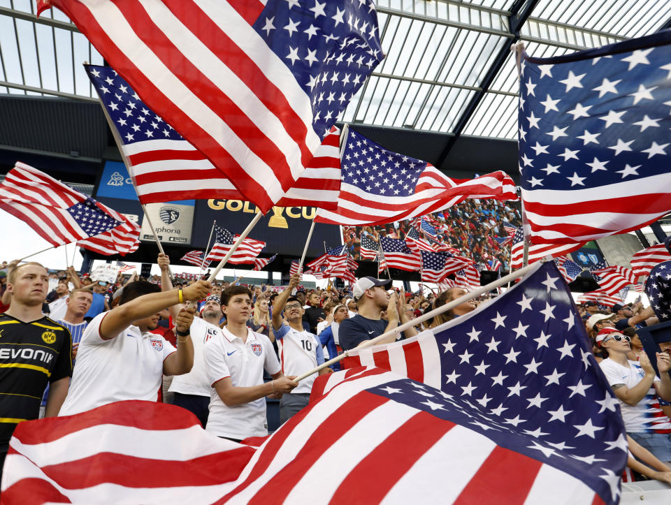 Fans of the U.S. team wave flags as the players are introduced for a CONCACAF Gold Cup soccer match against Panama in Kansas City, Kan., Wednesday, June 26, 2019. (AP Photo/Colin E. Braley)