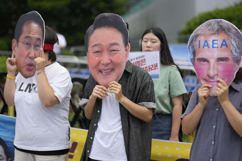 Students wearing masks of Japanese Prime Minister Fumio Kishida, South Korean President Yoon Suk Yeol, and Rafael Mariano Grossi, Director General of the International Atomic Energy Agency, perform during a rally to oppose the Japanese government's plan to release treated radioactive water into the sea from the Fukushima nuclear power plant, in Seoul, South Korea, Friday, July 7, 2023. (AP Photo/Lee Jin-man)