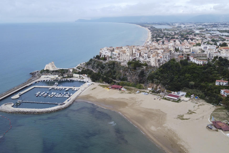 This aerial picture taken on Tuesday, April 28, 2020 shows an view of hilltop seaside town Sperlonga and its beaches, about 120km (80 miles) south of Rome. Though Italy is gradually reopening from a two-month lockdown, there is no word on when and how beach establishments can open for visitors. (AP Photo/Luigi Navarra)