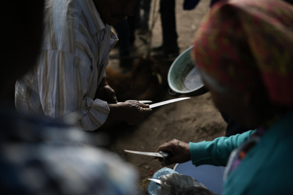 Raramuri Indigenous men choose a knife to slaughter a cow that will be cooked to feed those attending a sacred Yumari ceremony to ask for rain and good crops and to honor two local Jesuit priests, Javier Campos and Joaquin Mora, who were murdered in 2022 by a gang leader, in Cuiteco, Mexico, Saturday, May 11, 2024. Among the inhabitants of the Tarahumara mountains, especially among the Indigenous Raramuri people, priests are often regarded as profoundly beloved figures who fearlessly offer comfort and help. (AP Photo/Eduardo Verdugo)