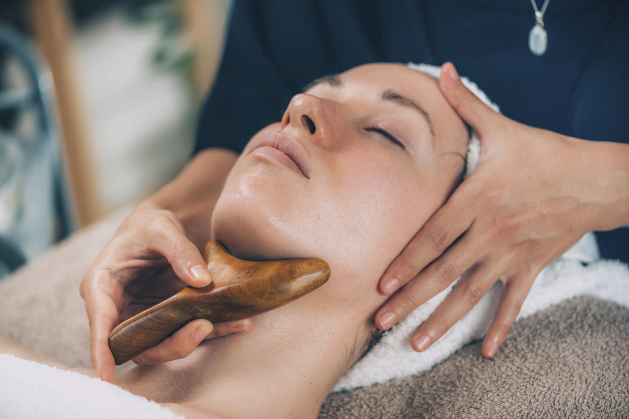 Lymphatic drainage face massage with wooden massager.