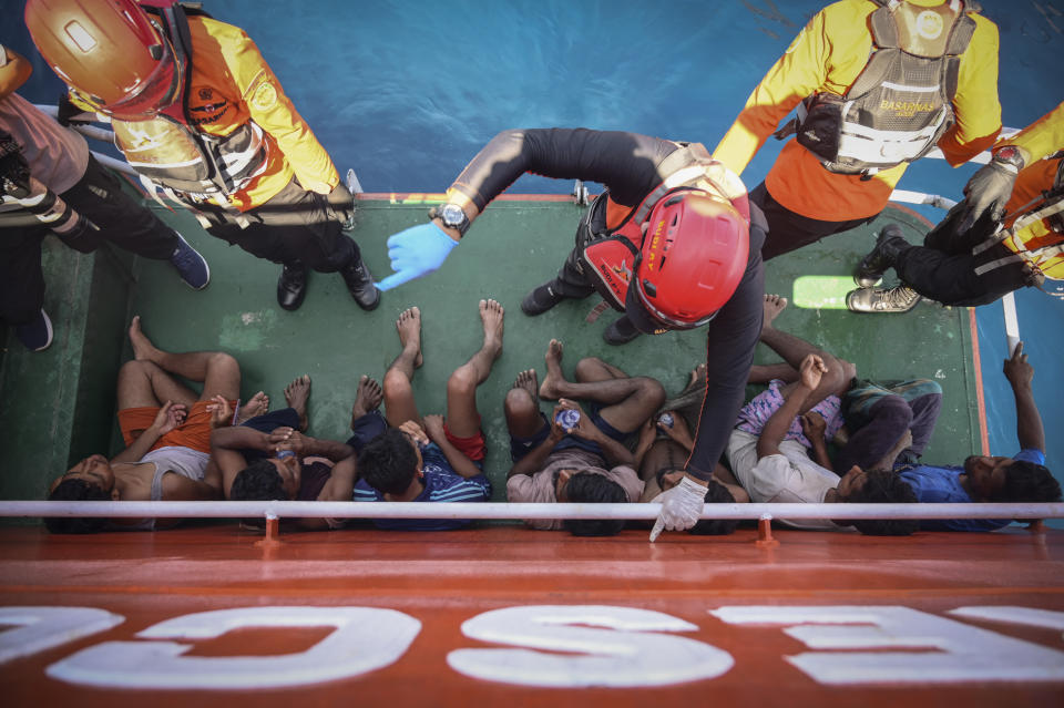 Members of Indonesia's National Search and Rescue Agency give instructions to Rohingya refugees rescued from a capsized fishing boat off West Aceh, Indonesia, on Thursday, March 21, 2024. The wooden fishing boat carried about 140 Rohingya refugees, but only 75 people were rescued. In interviews with The Associated Press, eight of the survivors described abuses on board the fishing boat. (AP Photo/Reza Saifullah)