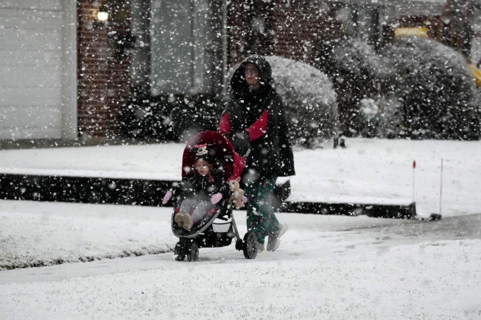 Pedestrians walk through the snow in Wheeling, Ill., Tuesday, Jan. 9, 2024. (AP Photo/Nam Y. Huh)