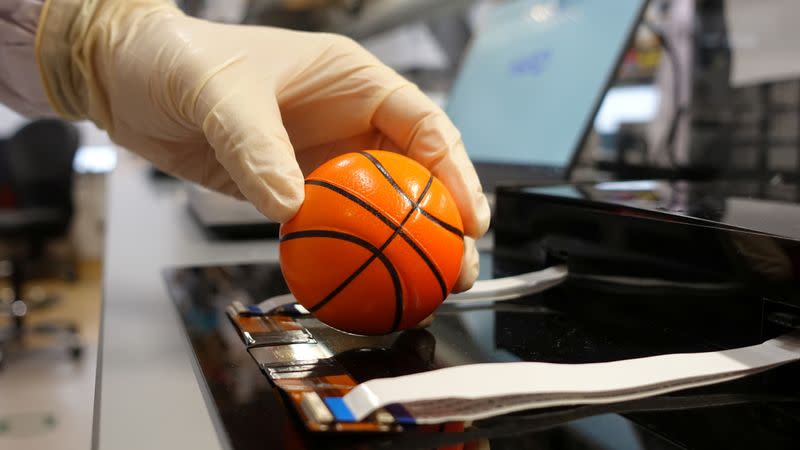 Dr. Benjamin Tee demonstrates how his device can detect the texture of a soft stress ball at a NUS lab in Singapore